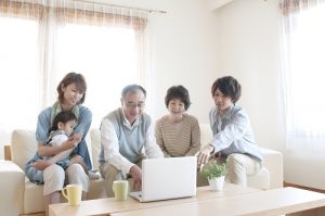 ノートパソコンを見る3世代家族